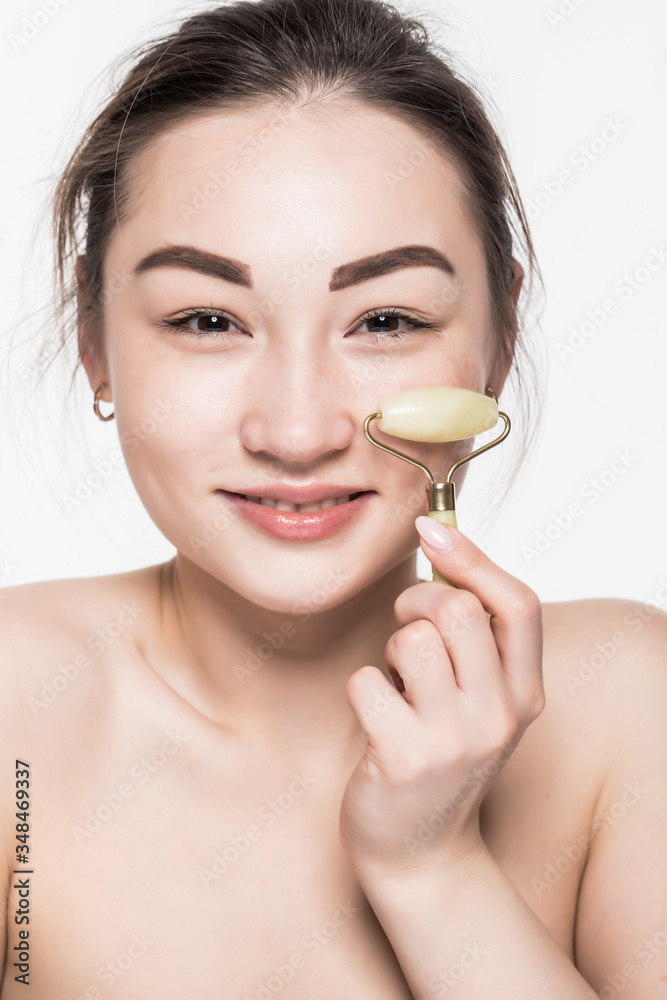 Beauty rose jade stone face roller for facial massage therapy. Portrait of Asian woman use jade aging roller isolated on white background. Beauty rose jade stone face roller for facial massage therapy. Portrait of Asian woman use jade aging roller isolated on white background.