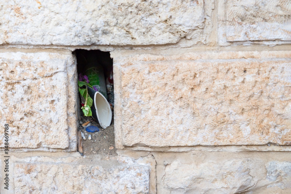 Niche or hole with garbage in the old wall in Jerusalem, Israel. Details, copy space