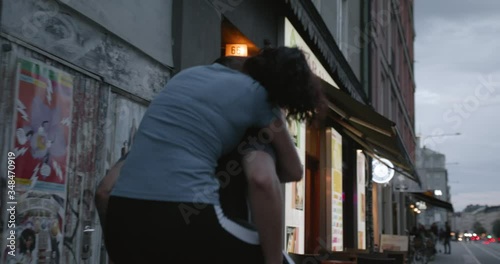 A young man carrying his girlfriend on his back in the city.