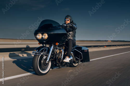 Fotografie Motorcycle driver riding alone on asphalt motorway
