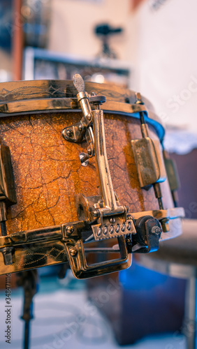 Close up shot of snare drum throw off mechanism and snare wires from the 1930s. Engraved guilt gold hoops