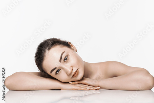 Charming asian woman face while lying isolated on white background