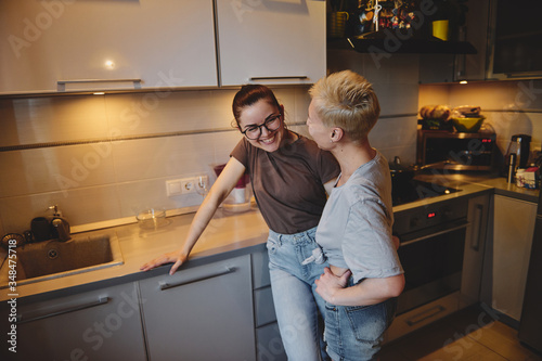 Two girls chatting with each other in the kitchen, love relationship same-sex couple girls. Family and family relationships.