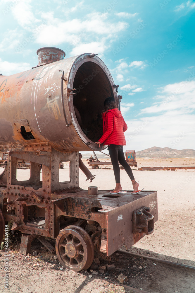 Tourist, Train Cemetry Bolivia Salt Flats. Bolivian salty desert and blue sky background. Shot in Salar de Uyuni. Rusted, waste, abandoned, locomotive graveyard, railroad concepts. Tourist attraction