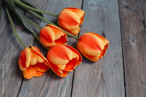 Bouquet of colorful tulips on old wooden background. Top view with copy space