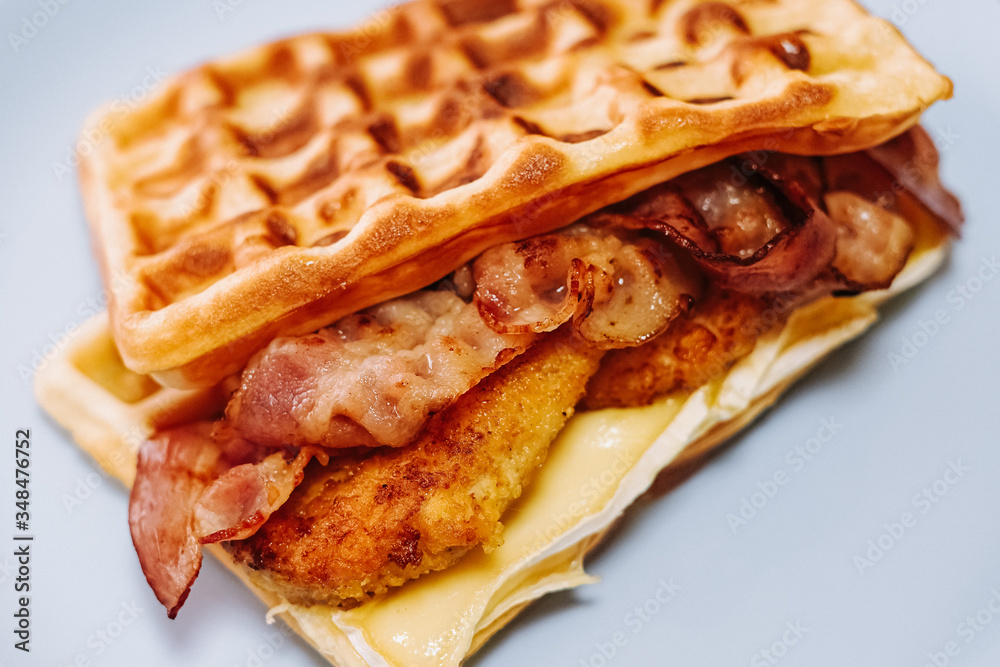 tasty Belgium waffle with lettuce, meat, egg and vegetables served of pretty blue plate tasty Belgium waffle with lettuce, meat, egg and vegetables served of pretty blue plate