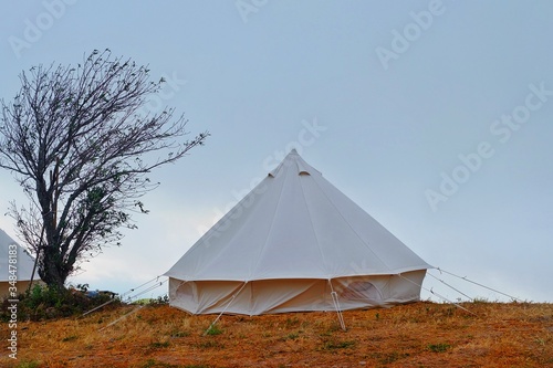 Scenic view of white tents on a hill top on a peaceful morning after a long hike. © Sirichai