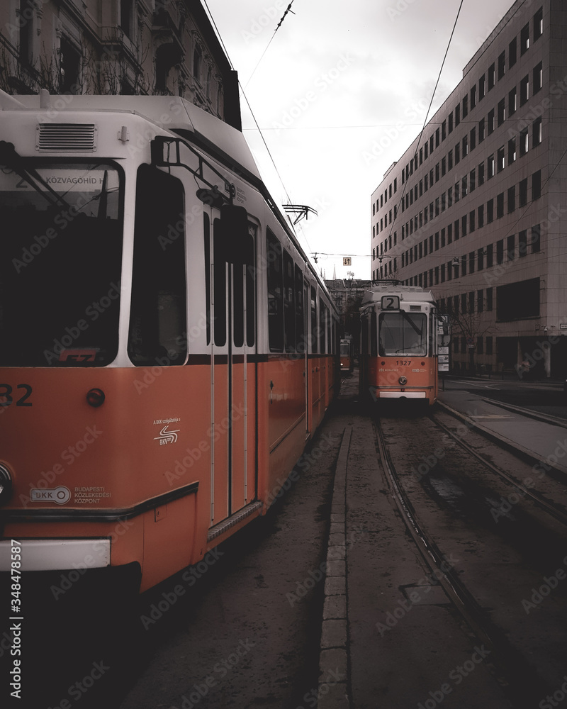 Orange Trains in caught in action in city streets of Budapest Hungary