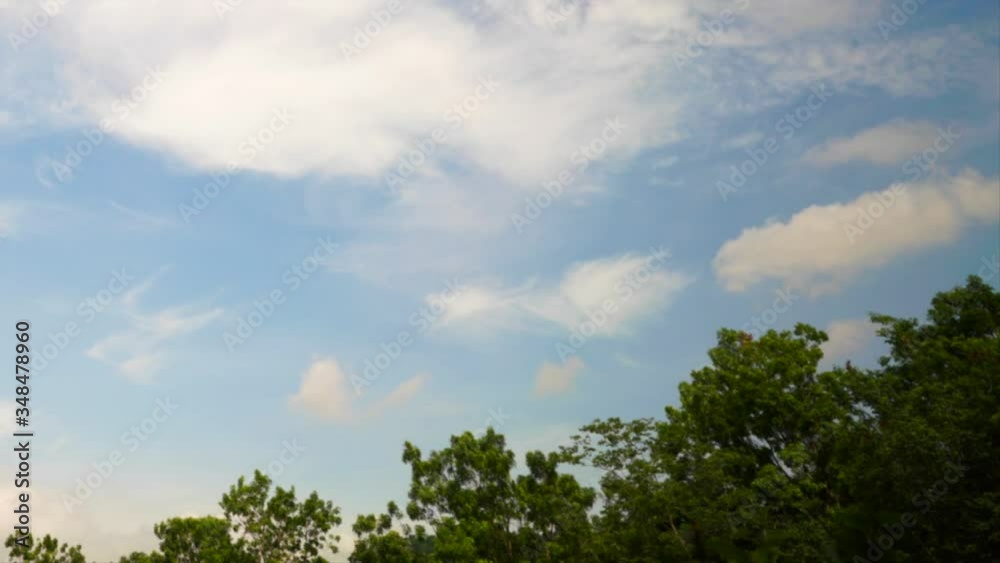 Motion clouds. Timelapse. Puffy fluffy white clouds on blue sky moving beautifully with trees at the foreground. Nature background. Motion clouds. Timelapse. Puffy fluffy white clouds on blue sky moving beautifully with trees at the foreground. Nature background.