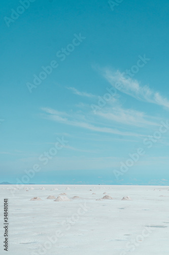 SALT. Salt Flats Uyuni Bolivia. Desert like Landscape with blue sky  clouds and empty space. Holiday  vacation  adventure  freedom. Copy space. Car tyre marks on road.