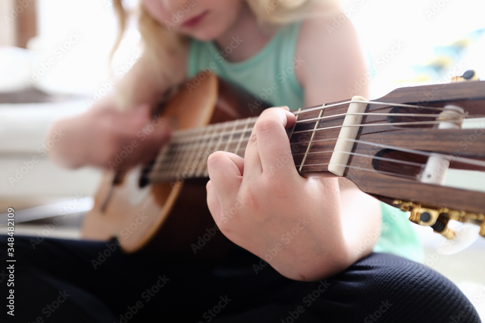 Fototapeta premium Mädchen beim Gitarre spielen