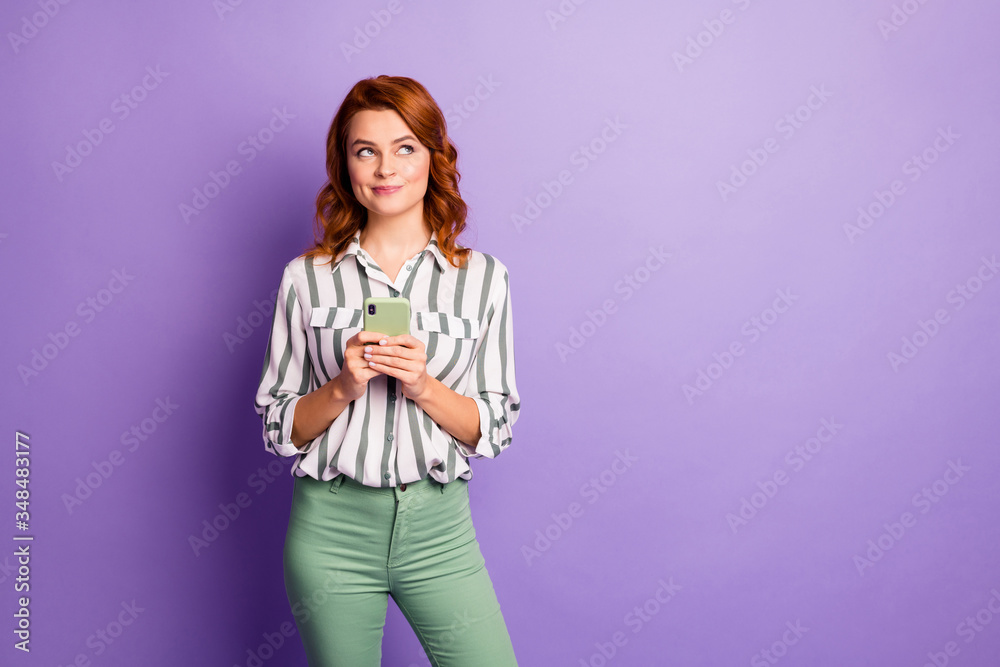 Portrait of interested minded woman blogger use smart phone think thoughts want post comment feedback wear stylish clothing isolated over purple color background Portrait of interested minded woman blogger use smart phone think thoughts want post comment feedback wear stylish clothing isolated over purple color background