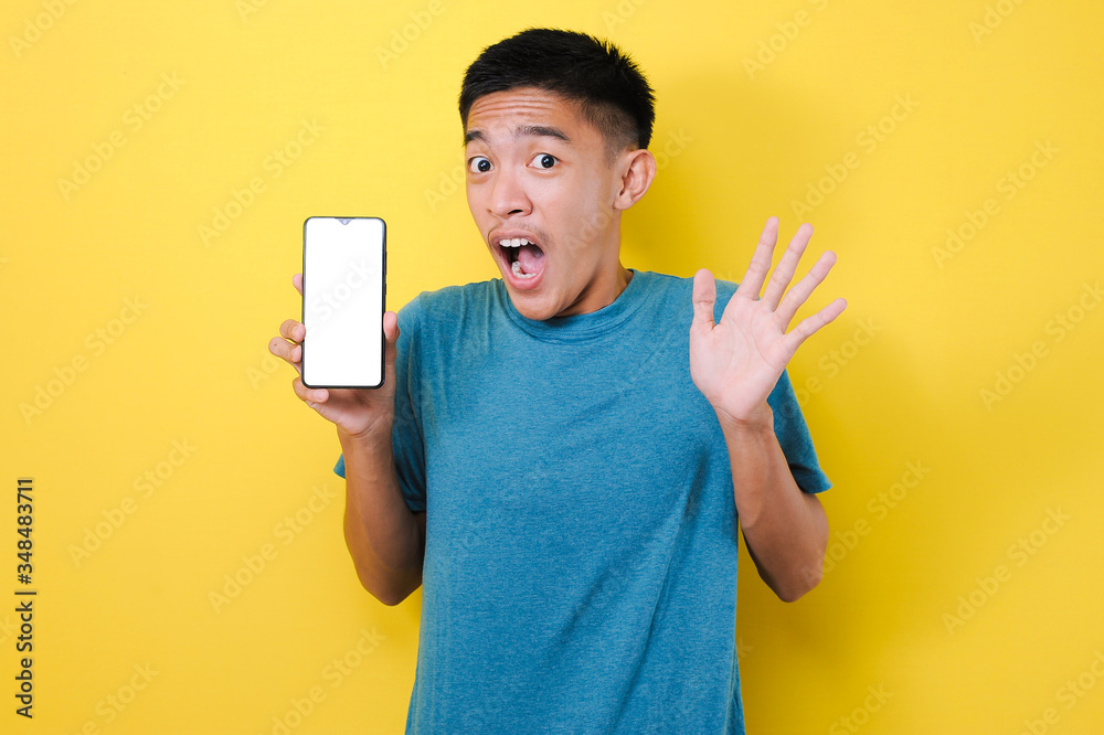 Young Asian teenager doing winning gesture holding mobile phone, Happy get special gift online Young Asian teenager doing winning gesture holding mobile phone, Happy get special gift online