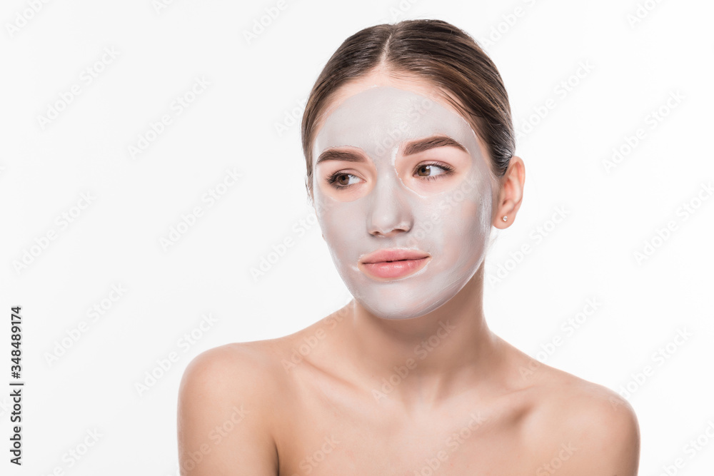 Beautiful woman with eyes closed and white clay facial mask on face on white background