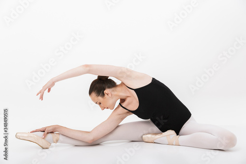 Image of caucasian woman ballerina practicing and stretching her body