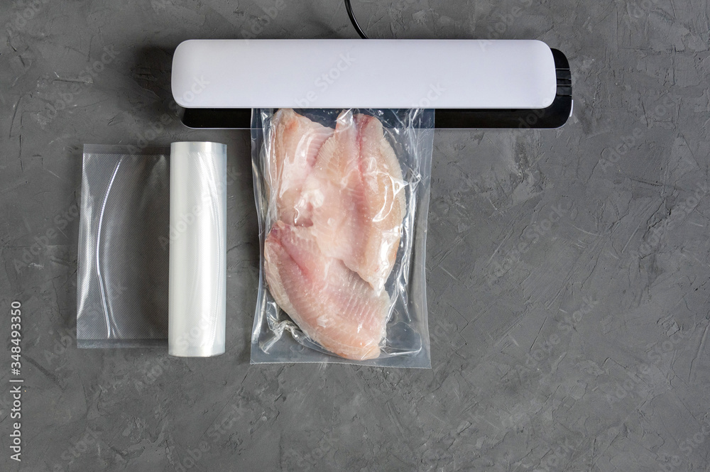 Vacuum fish packaging for longterm storage. Tilapia fillet in a vacuum bag. Stock Photo Adobe