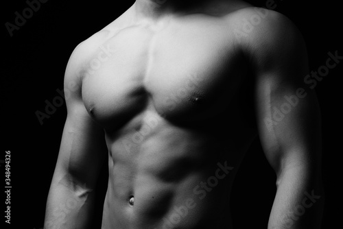 Muskulöser Männerkörper vor schwarzem Hintergrund 