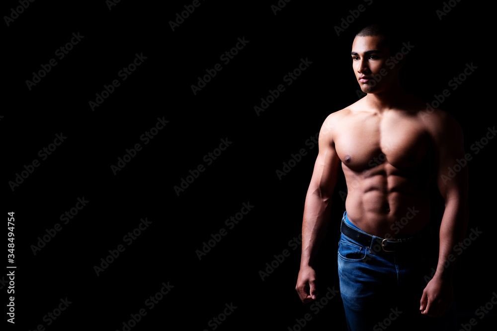 Fototapeta premium Portrait eines attraktiven, muskulösen und hübschen Mannes oberkörperfrei vor schwarzem Hintergrund 
