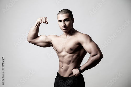 Attraktiver muskulöser Mann posiert vor grauem Hintergrund