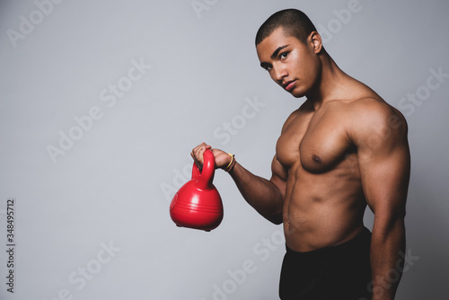 Junger muskulöser Mann trainiert mit einer Kugelhantel, Training mit einer Kettlebell 