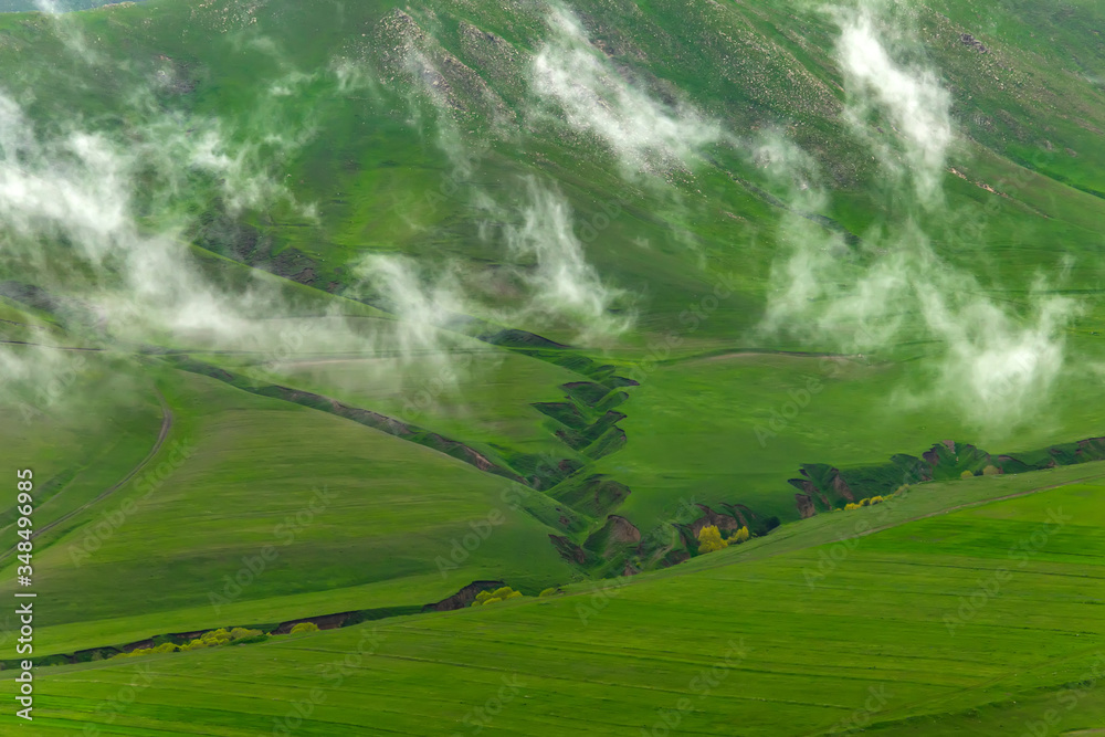 Fototapeta premium Pieces of fog on the green mountains