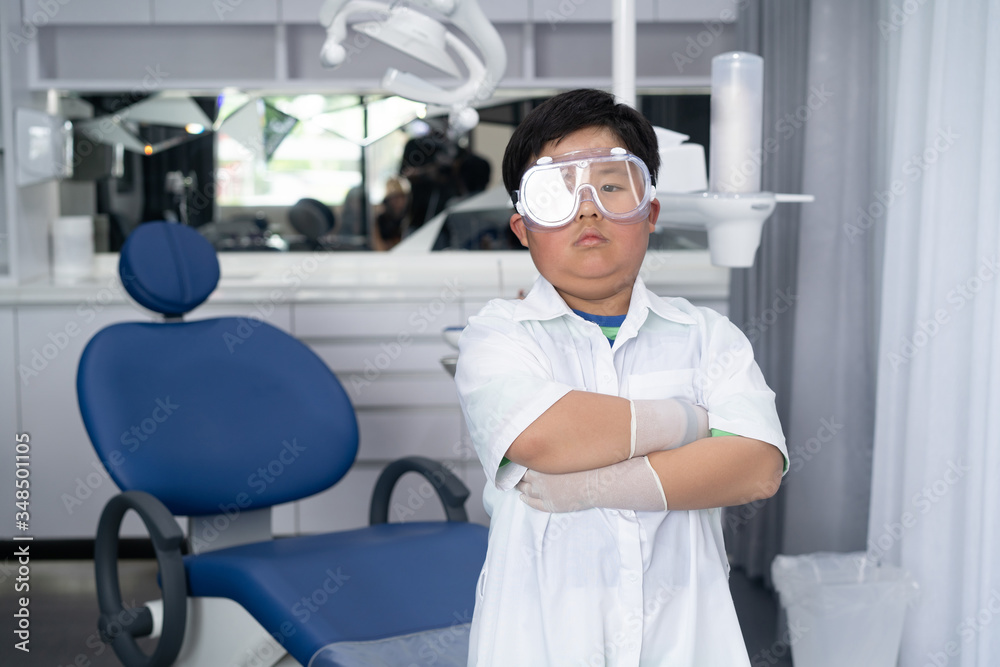Little Asian doctor dentist boy with a dentist suit, standing in the dentist clinic. Little Asian doctor dentist boy with a dentist suit, standing in the dentist clinic.