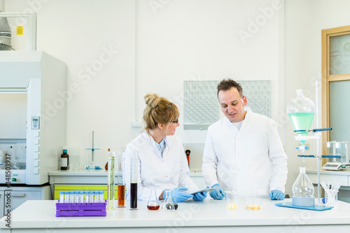 Two scientist working with tablet in CBD hemp laboratory