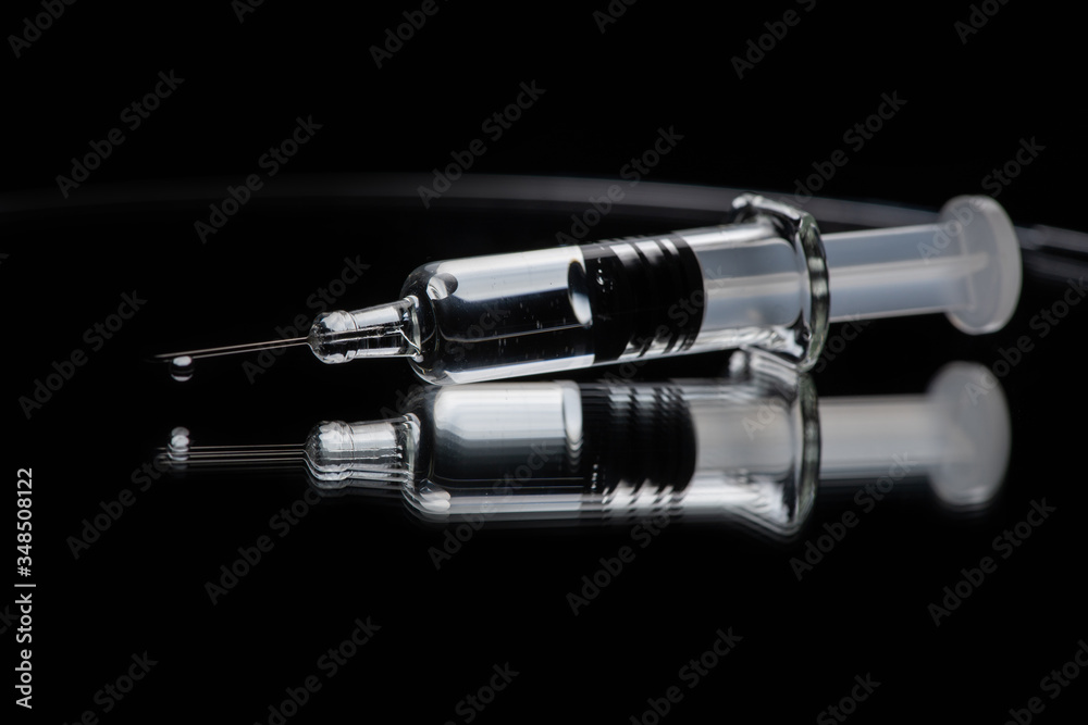Glass syringe with reflection on white background. Concept about vaccine of coronavirus or COVID-19. Glass syringe with reflection on white background. Concept about vaccine of coronavirus or COVID-19.