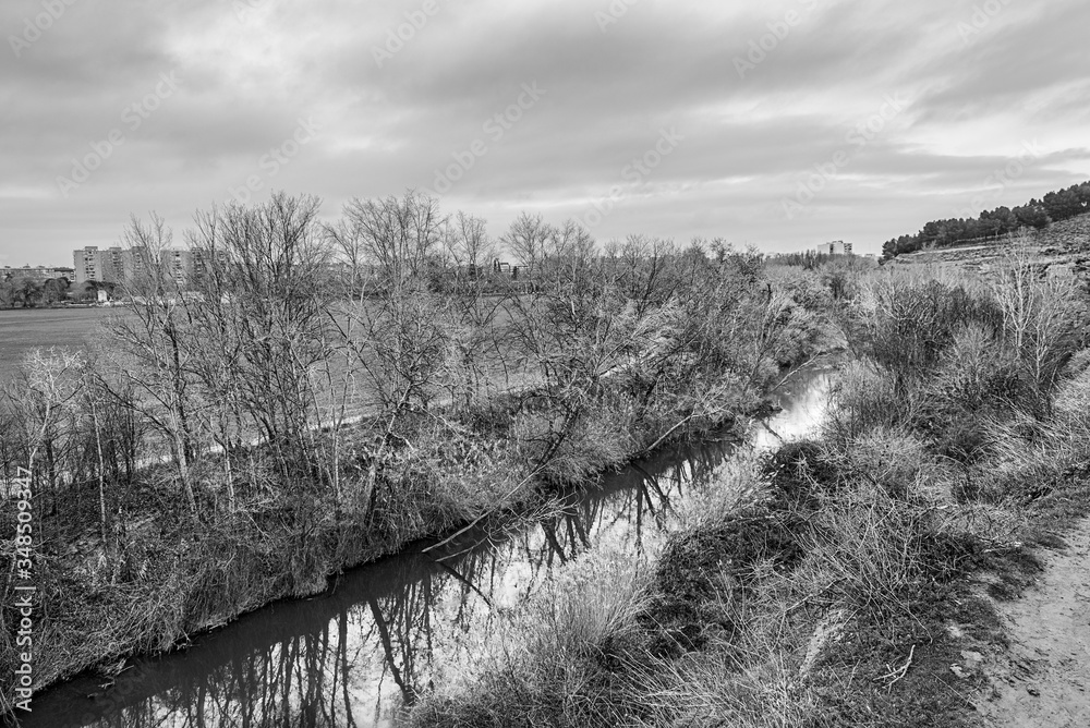 Henares river as it passes through Alcalá de Henares in winter: view from the park of the hills in the opposite direction of the current.