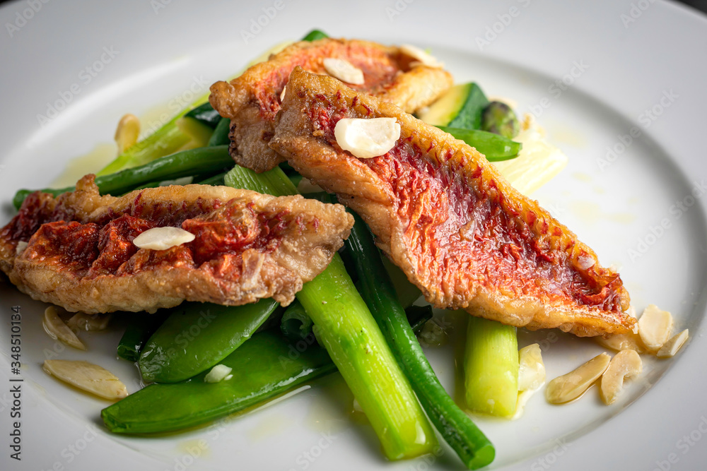 Grilled fish fillet with asparagus, sauce on a dark background Grilled fish fillet with asparagus, sauce on a dark background