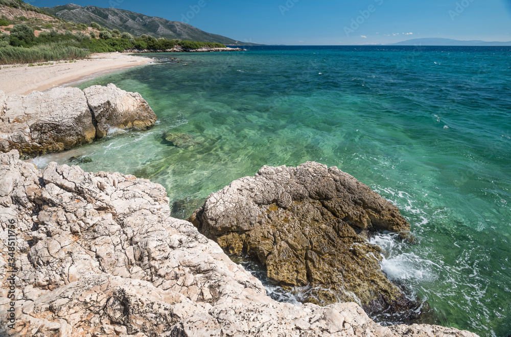 among the rocks, a little white sand beach and the turquoise water of the Mediterranean sea