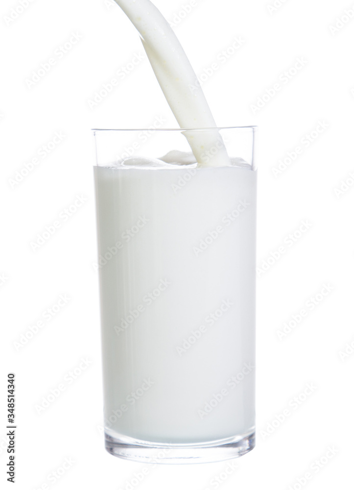 pouring milk in glass isolated on white background pouring milk in glass isolated on white background