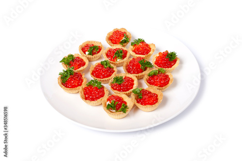 Tartlets with red caviar on a white plate. Gourmet food, appetizer. salmon caviar. Deli. Gourmet food. Seafood. On white highlighted background.