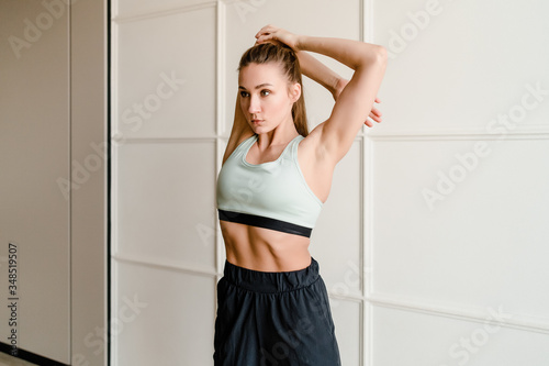 sporty young woman stretching and doing exercise at home