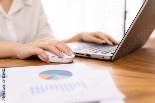 Young woman sale person analzing sale report on desk working at home