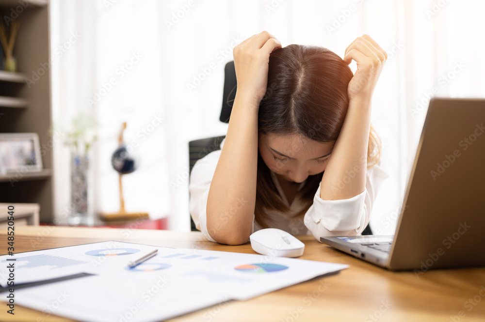 Stressed young Asian woman using laptop working at home Stressed young Asian woman using laptop working at home