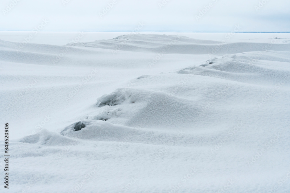 The smooth lines of snow drifts with a granular structure