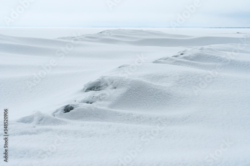 The smooth lines of snow drifts with a granular structure