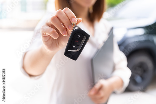 Car loan, contract agreement,buying and rent car concept, Saleperson holding car key on hand