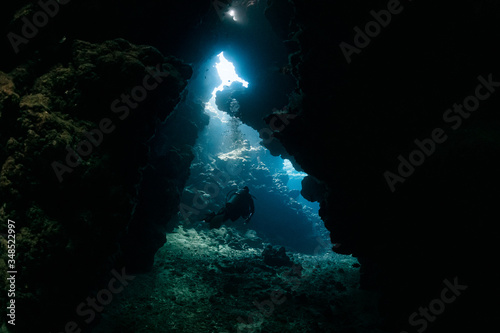 typical underwater cave in a red sea reef with an underwater photographer diver © Subphoto