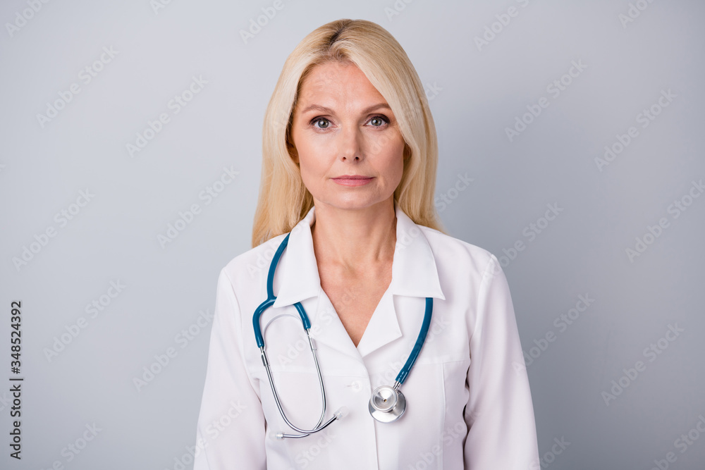 Portrait of serious qualified old woman executive doc ready stop covid-19 spreading infection wear white coat isolated over gray color background Portrait of serious qualified old woman executive doc ready stop covid-19 spreading infection wear white coat isolated over gray color background
