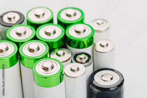 many new and used alkaline the positive ends of battery cells. type AA on a light background.