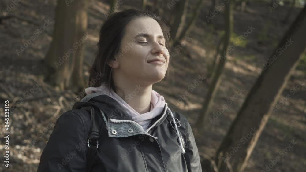 Close-up of smiling young woman taking off face mask and inhaling fresh air in spring park. Happy Caucasian brunette girl enjoying sunny day outdoors after Covid-19 lockdown. Joy, lifestyle, pandemic. Close-up of smiling young woman taking off face mask and inhaling fresh air in spring park. Happy Caucasian brunette girl enjoying sunny day outdoors after Covid-19 lockdown. Joy, lifestyle, pandemic.