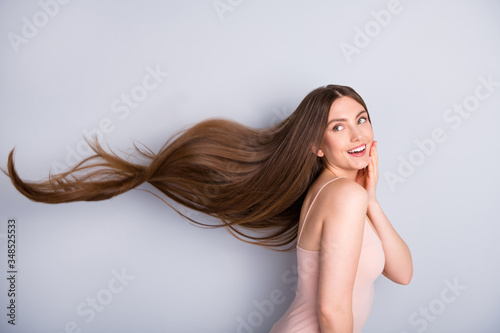 Profile photo of attractive cute model lady demonstrating ideal neat long healthy hairstyle flying on air after lamination procedure wear beige singlet isolated grey color background