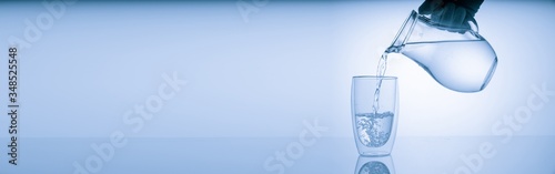 Pitcher with drinking water and a glass with a drink, blue tone