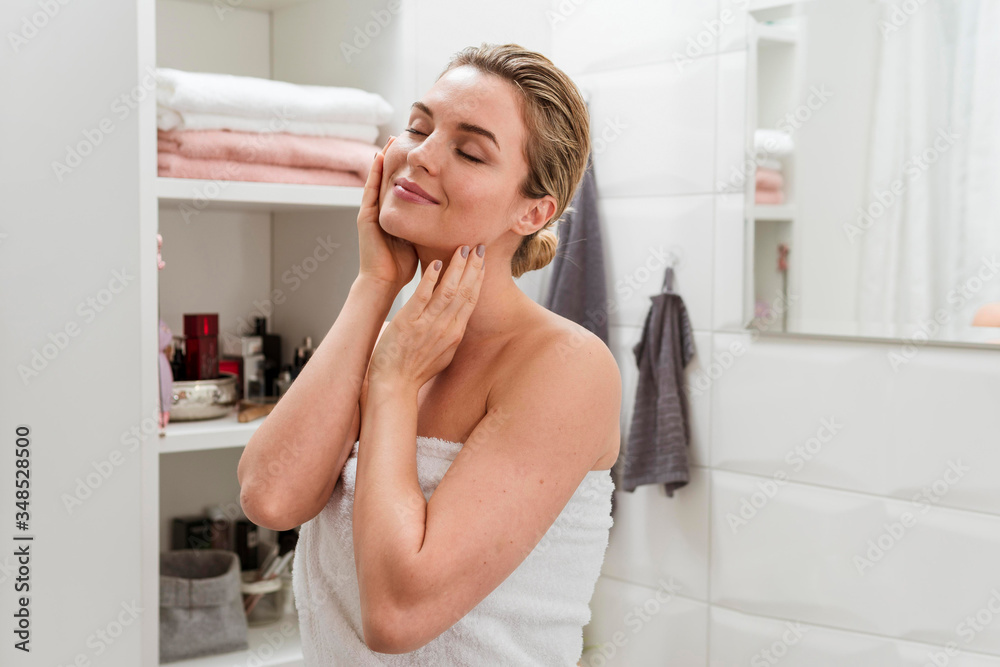 Woman in towel touching her face Woman in towel touching her face