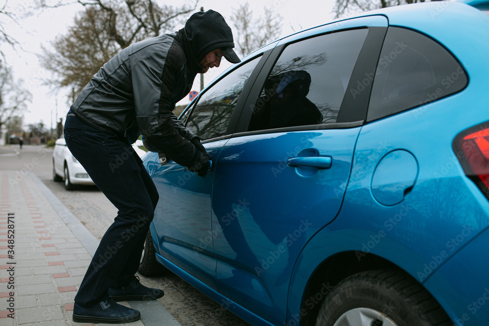Car thief stealing a car at the car door,
glove robber breaks the law, hacks the lock on the car to get inside Car thief stealing a car at the car door,
glove robber breaks the law, hacks the lock on the car to get inside