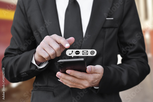 Close-up of Businessman hand holding smartphone with icon (mobile phone, and email address). Concept of customer service call center contact. contacting information on business.