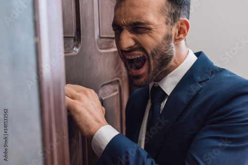 Konstfotografi Selective focus of angry collector shouting and knocking on door