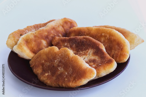 Fried pies with filling on a white table © Irina